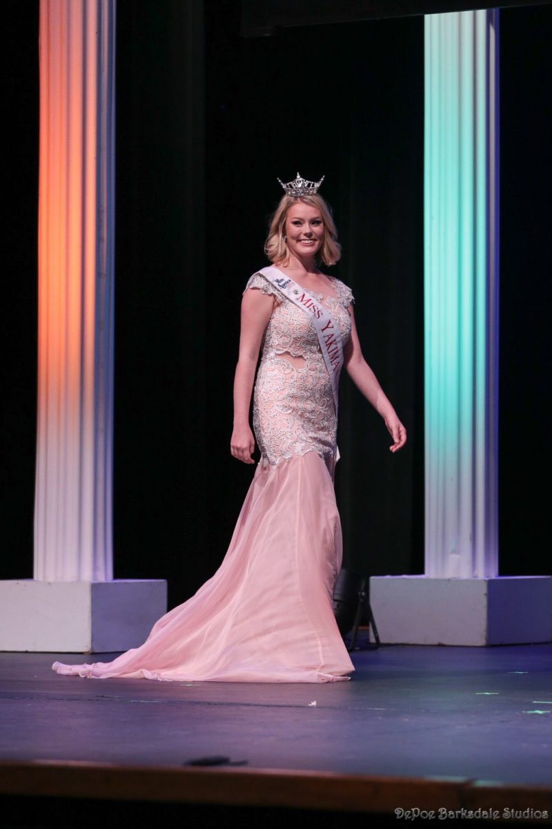 Beauty pageant winner struts across stage in flowing pink Mac Duggal gown